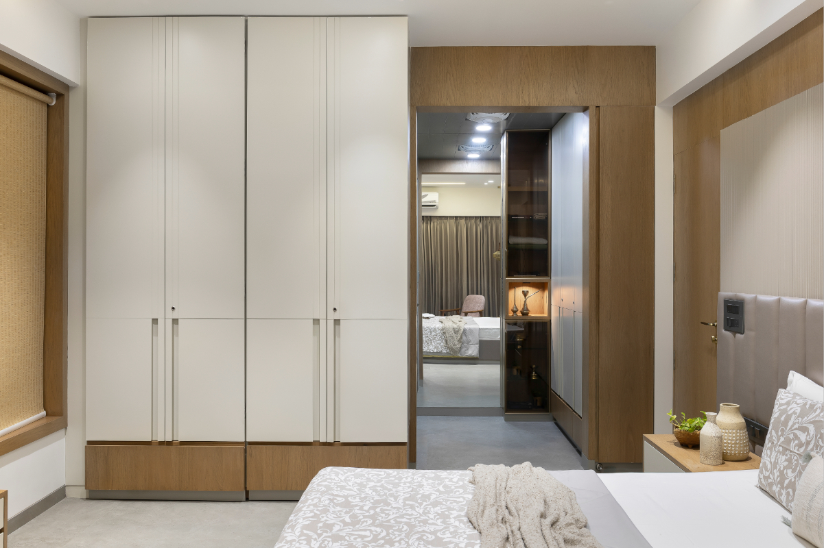 The parents' bedroom — white wardrobe with timber banding, a doorway opens to the adjacent room beyond