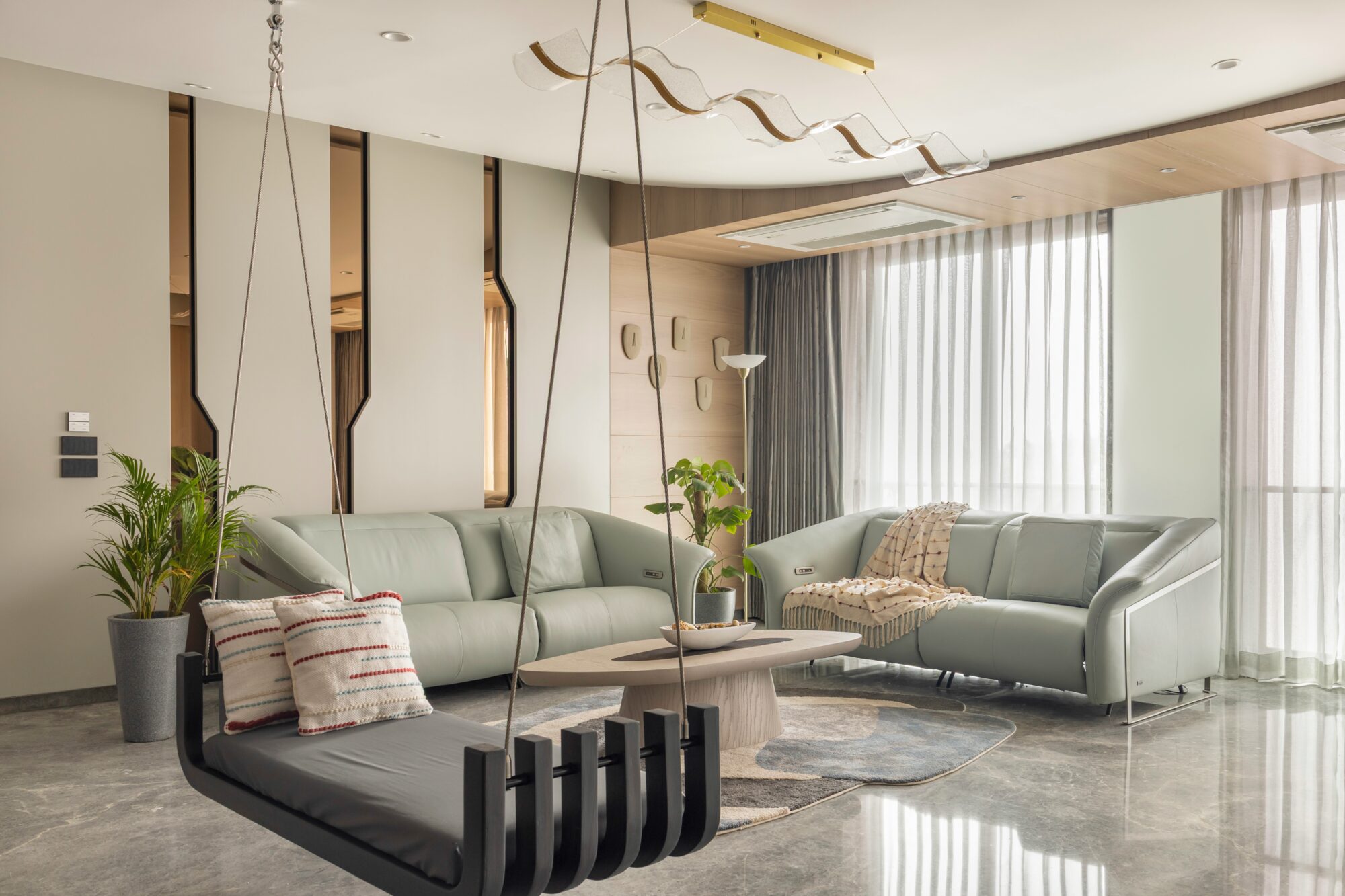 The Penthouse living room — diagonal LED light cutting across the TV wall, framed by the jhula