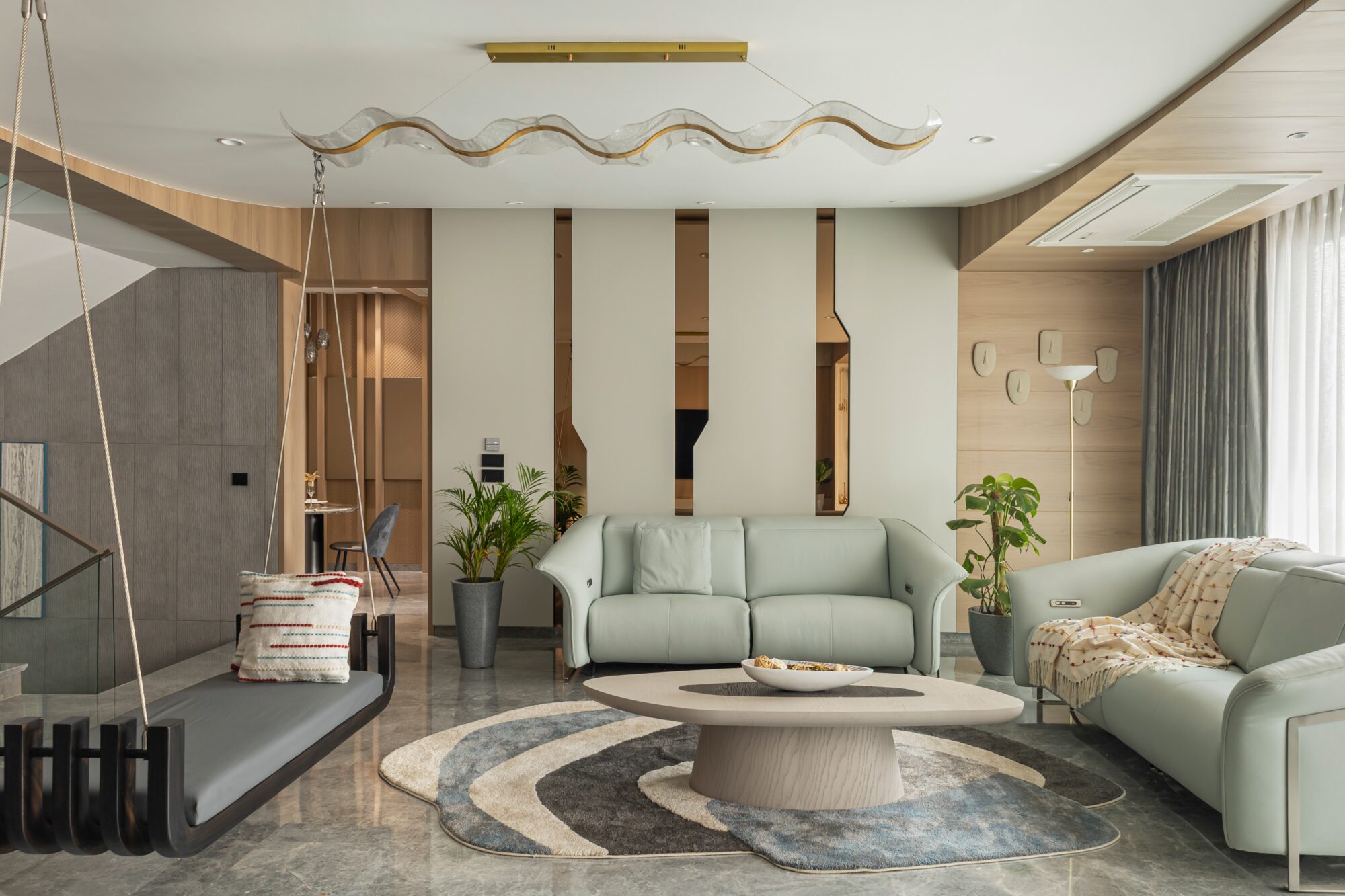 The Penthouse foyer — central backlit staircase rising to the terrace level, oak-clad spine, glass balustrade