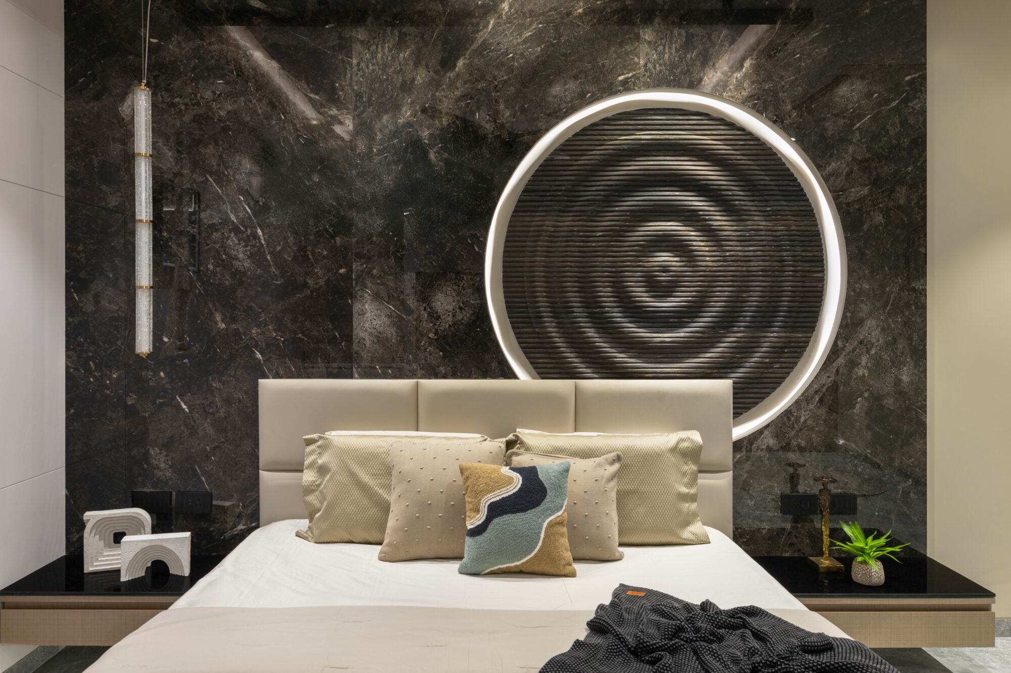 Younger son's bedroom — black stone wall with circular ribbed art panel