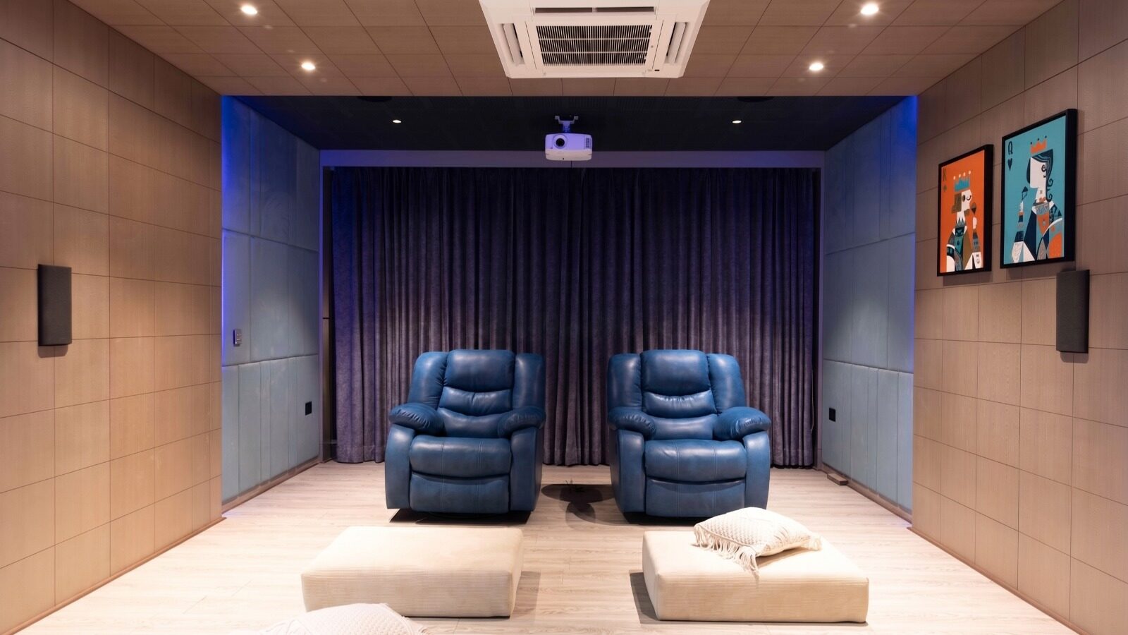 Home theatre with blue recliners and acoustic panelling