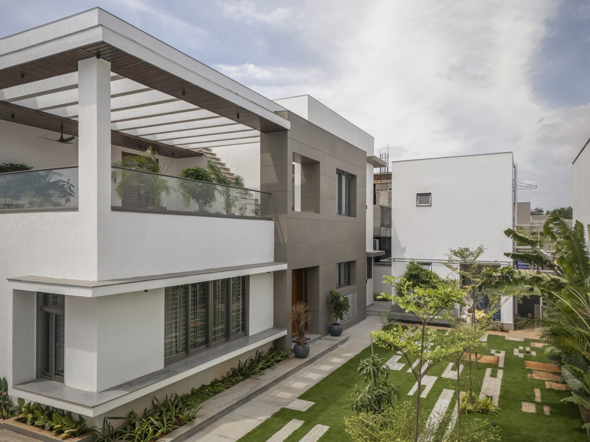The west elevation of the residence with first-floor open-to-sky pergola and ground-floor garden