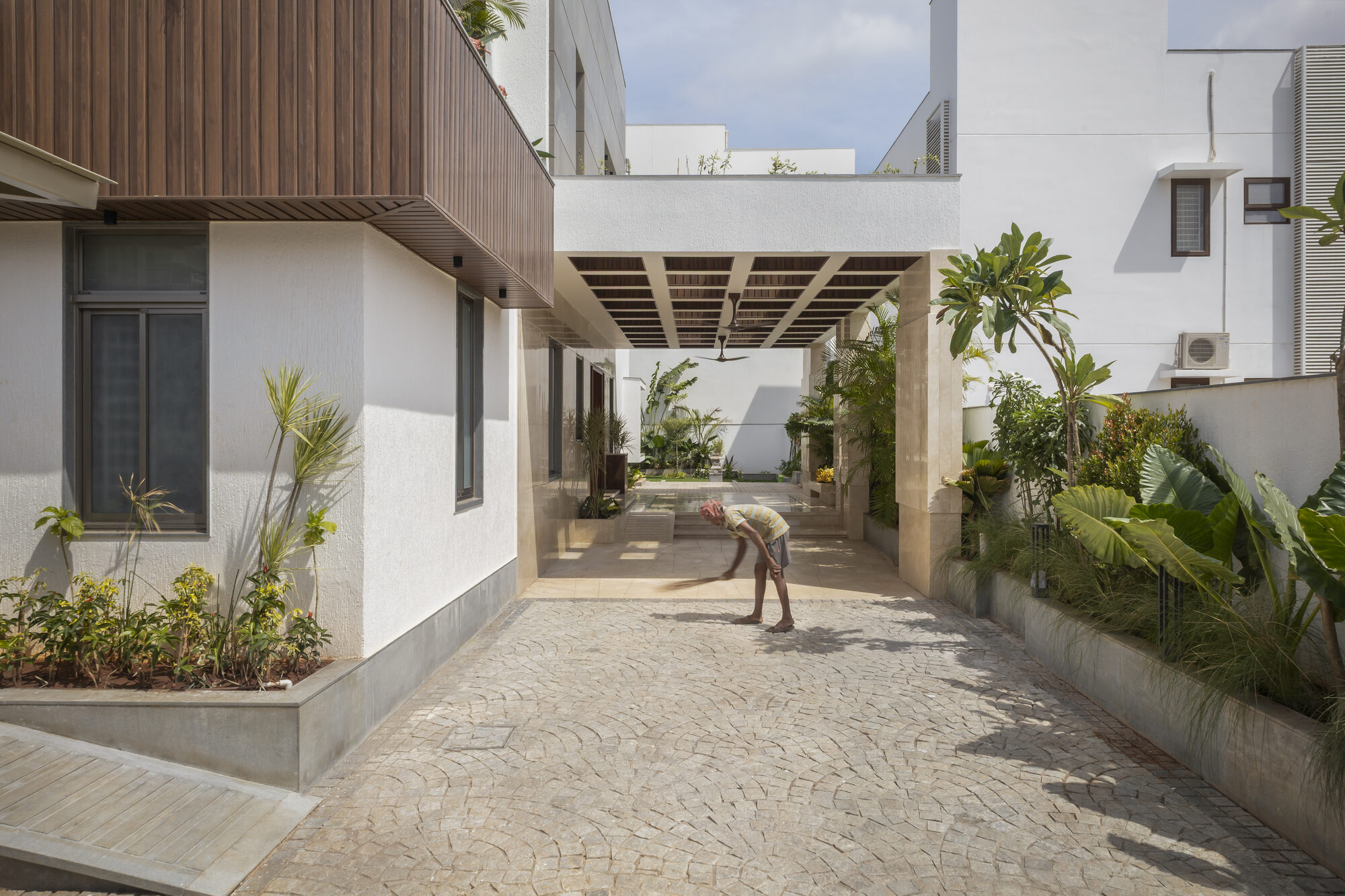 Side garden walkway with stone paving leading to a covered shaded verandah